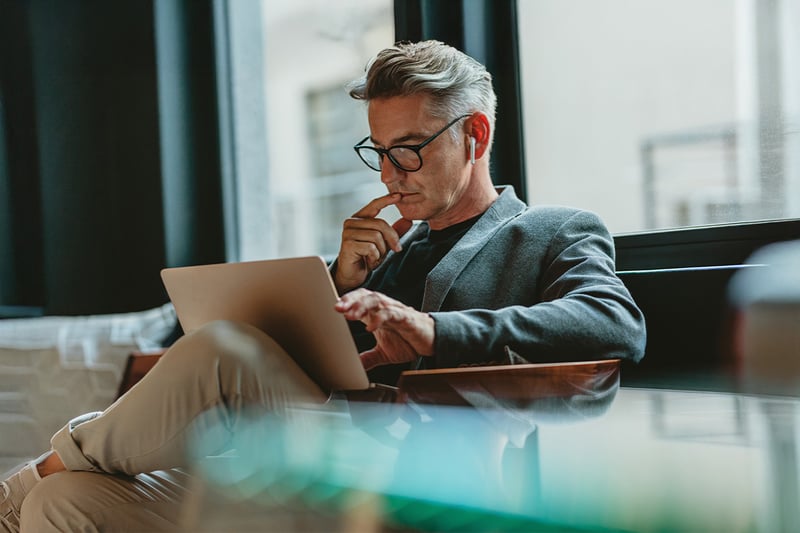 man-watching-video-on-laptop-in-office-lobby