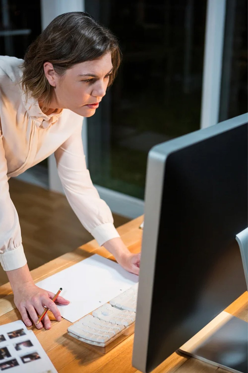 businesswoman-working-on-computer-at-her-desk-in-the-office-VERTICAL