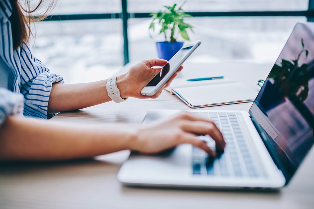 female-office-professional-multitasking-from-two-devices