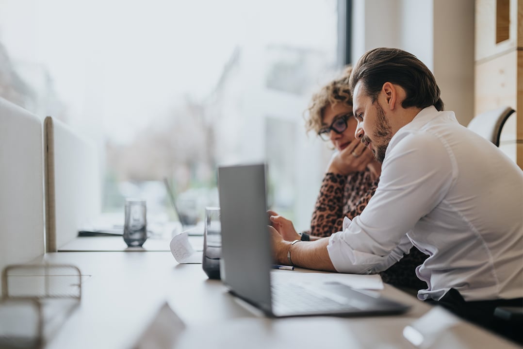 focused-colleagues-studying-laptop-in-office