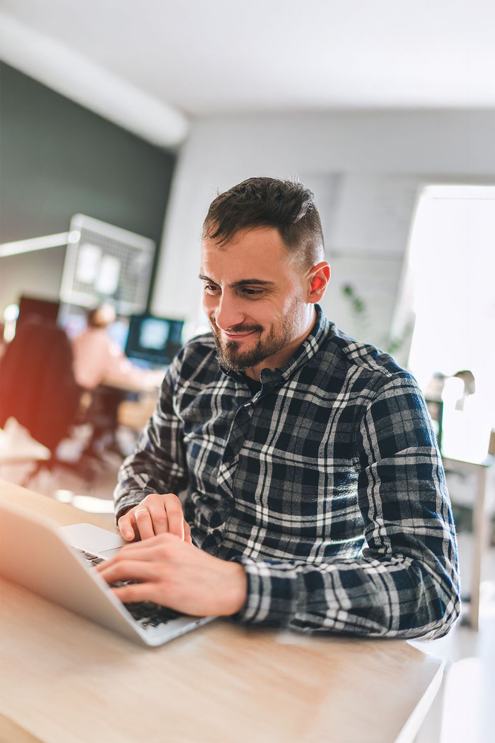 smiling-growth-strategist-working-on-laptop-in-office