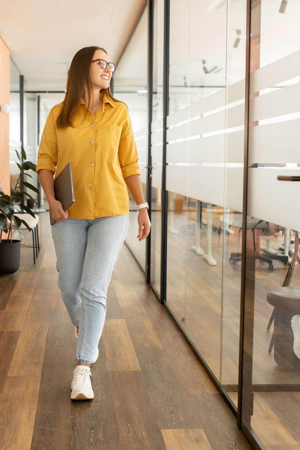 smiling-young-female-project-manager-walking-with-ipad