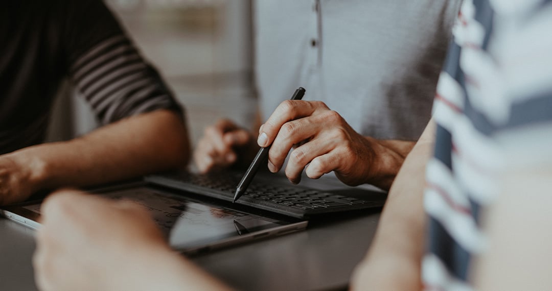 team-watching-man-using-stylus-on-tablet