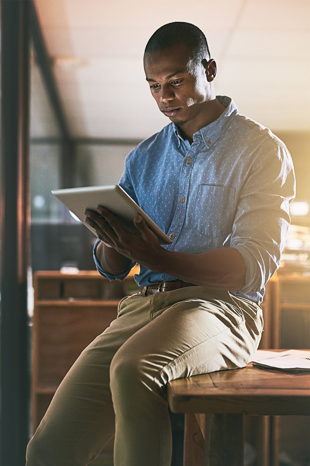 young-male-in-modern-office-studies-data-on-ipad